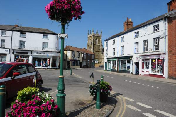 Alford street with shops and a church