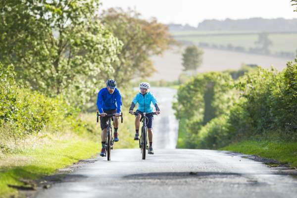 Two people cycling down a country lane
