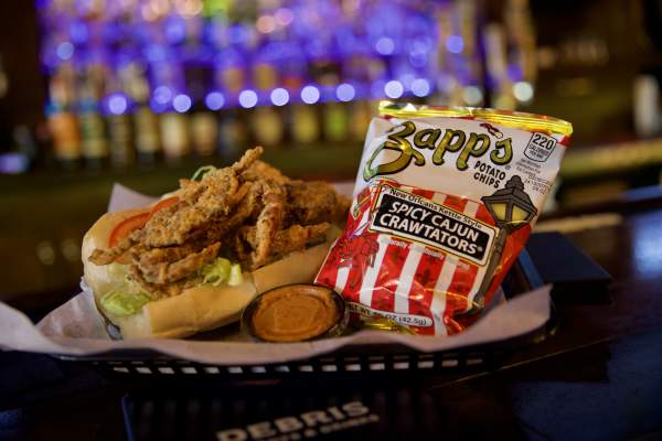 Fried Soft Shell Crab Po-boy and a bag of chips in a basket at Debris Po-Boy