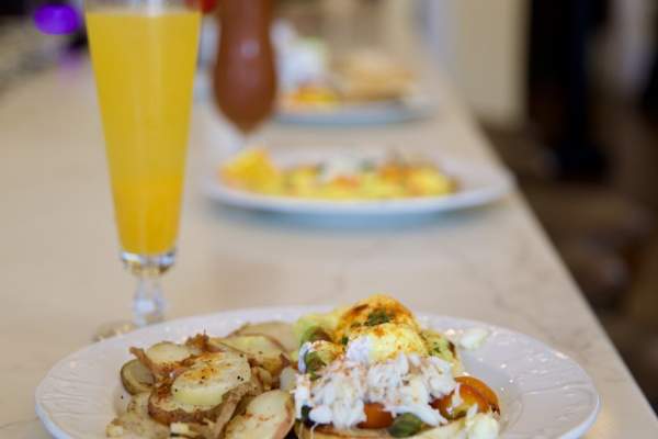 Breakfast plate on a bar with a mimosa cocktail