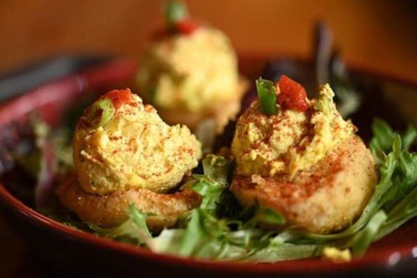 Three fried deviled eggs on a plate with lettuce