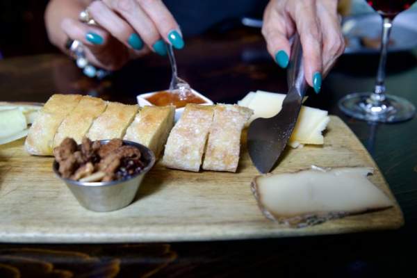 Charcuterie board with bread, nuts, cheese and preserves