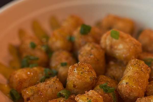 Tater tots in a bowl with scallions