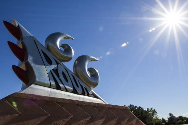 a large silver statue mimicking the taillights of an older style vehicle glistens in the bright sun, the statue reads "Route 66"