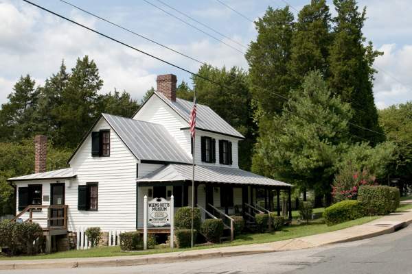 A historic white building with trees behind it