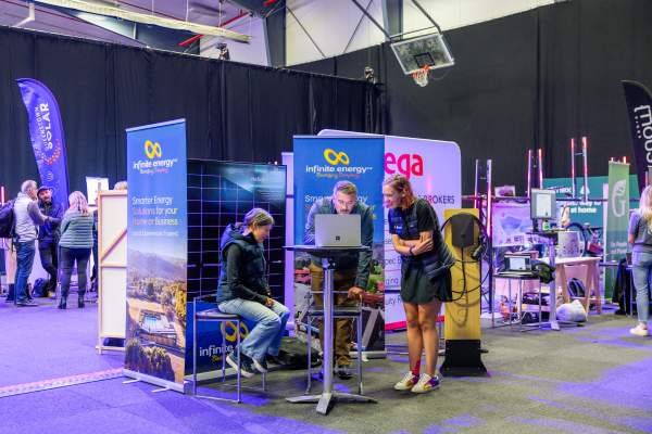 People gather around looking at technology at an exhibition