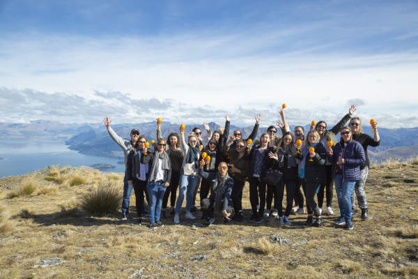 Group of people on top of a mountain posing with glasses of champagne