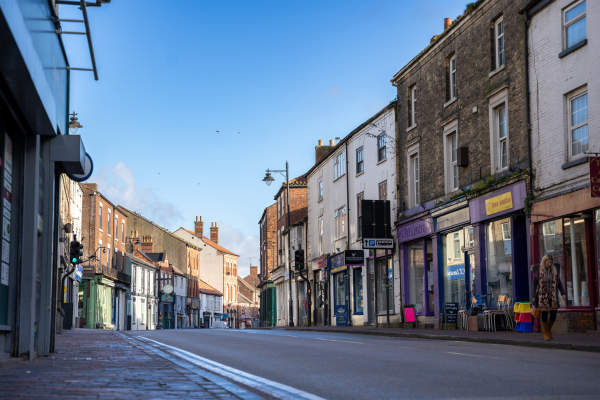 A high street lined with shops in early morning light