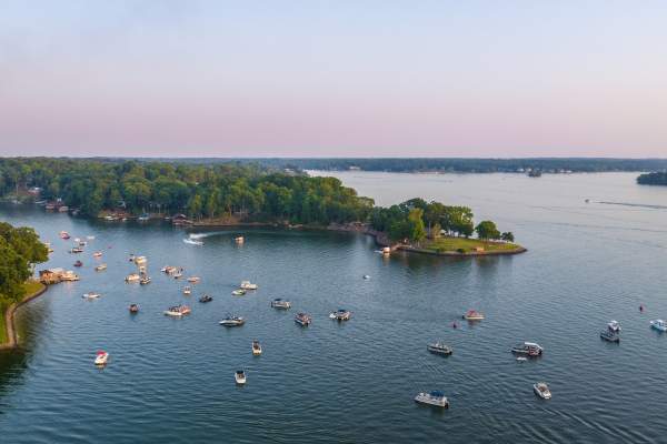 Lake with many boats on it with a piece of land seen