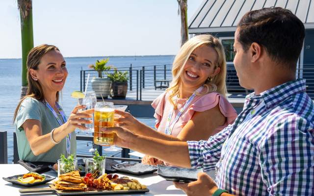 People toasting with beer and cocktails at Village Brewhouse at Fishermen's Village in Punta Gorda