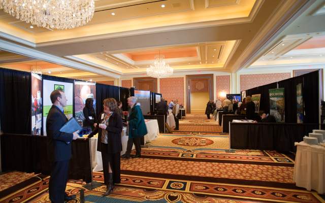 Business people at a conference chat outside vendor booths in Cheyenne, WY