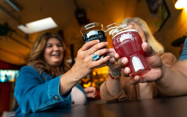 Group of friends clink pints of beer at Freedom's Edge Brewing Company in Cheyenne, WY