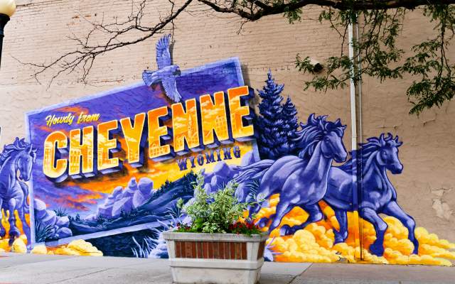 A mural of horses and sunsets that reads Cheyenne