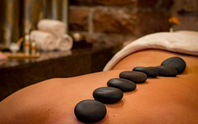 Woman receiving hot stone massage therapy