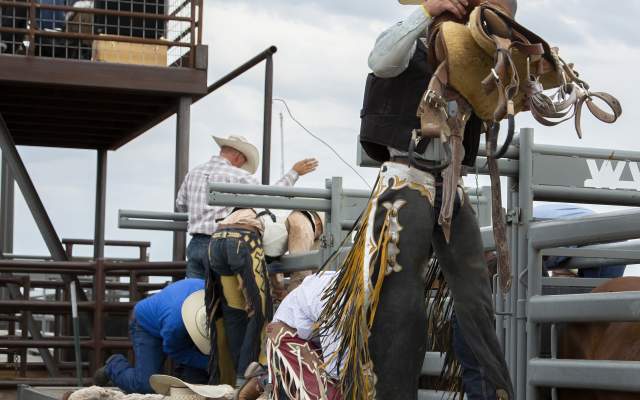 Cowboys prepare their equipment at the Hell on Wheels Rodeo