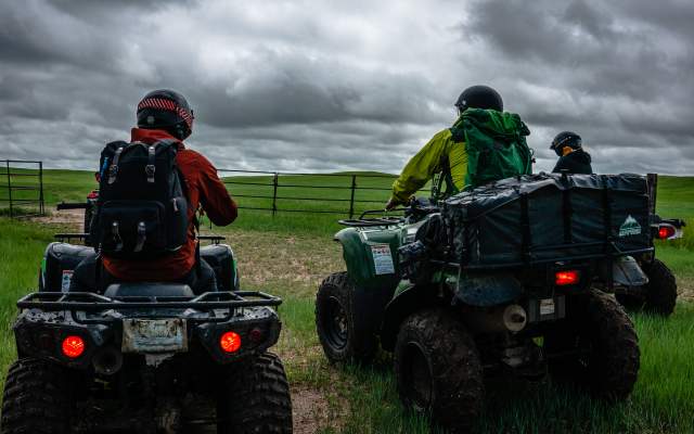 Adults ride ATVs at Terry Bison Ranch