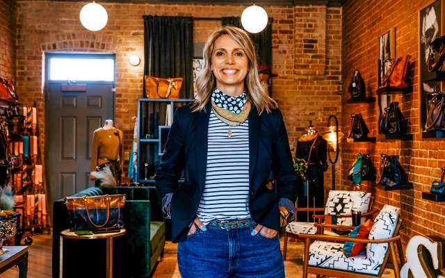 Alexis Garrett smiles in her Cheyenne studio, surrounded by handcrafted leather goods and accessories.