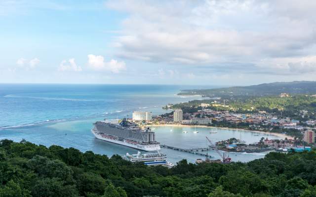 View of Ocho Rios as seen from the surrounding hills. A cruise ship is in the harbour at the pier.