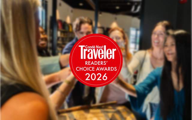 Group of friends cheering with shots of bourbon, overlaid with a Condé Nast Traveler Readers' Choice Awards seal.