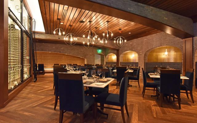 A spacious dining area with wooden accents, brick walls, and arched alcoves.