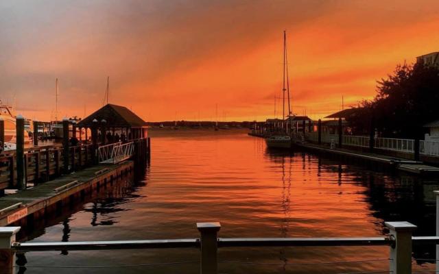 a sunset over a body of water with a dock