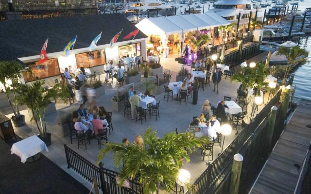Aerial view of a waterfront dining area with people seated at tables.