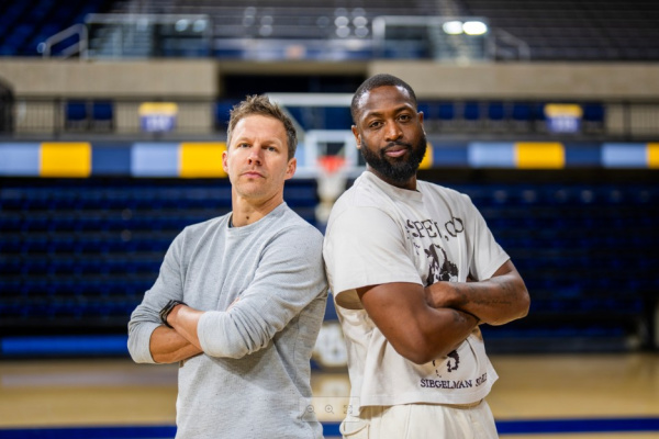 Wade & Diener on basketball court, back to back with arms crossed