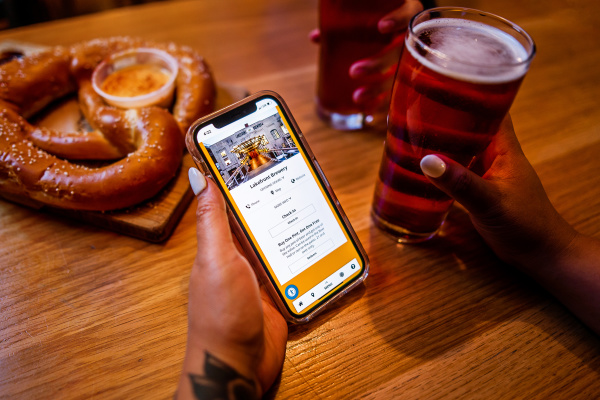 hand holding cellphone displaying lakefront brewery on the brew city beer pass
