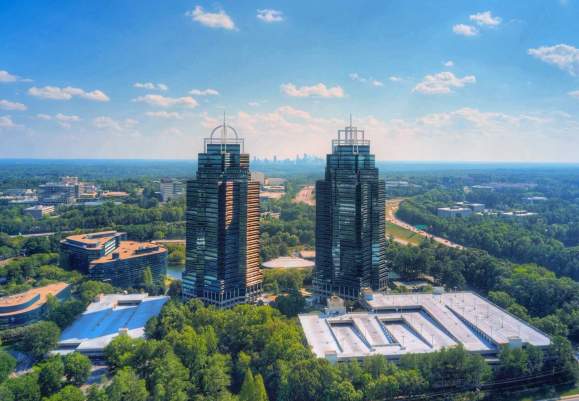 Aerial shot of the King & Queen in a vibrant green and blue setting. Clouds are scattered in the sky.