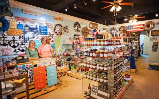 Shop owners proudly displaying handmade gifts, crafts, and local products inside a boutique store in Fayetteville, NC.