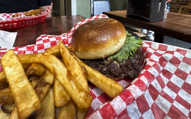 A burger and fries sits on a checkered parchment at a Restaurant in Fayetteville.