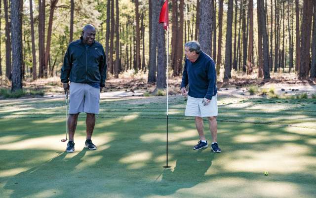 Two men laughing around a golf flag at Cumberland County's Bayonet Golf Course