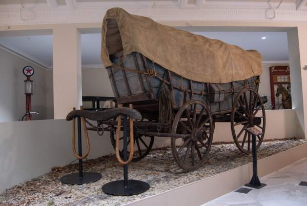 Conestoga Wagon on a gravel base on display at a museum.