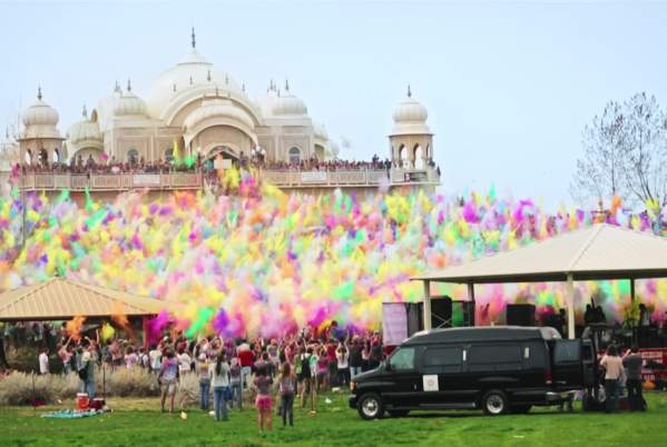 Large group of people throwing colorful chalk at the Krishna Temple in Spanish Fork for the Holi Festival of Colors