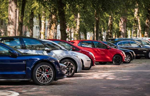 A row of cars parked underneath trees - Credit Michael Fousert