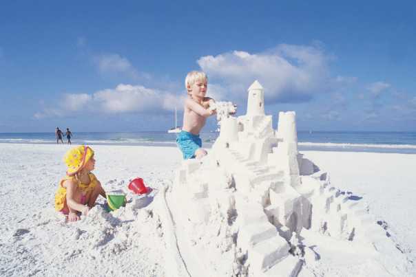 Children build a sandcastle on Siesta Beach