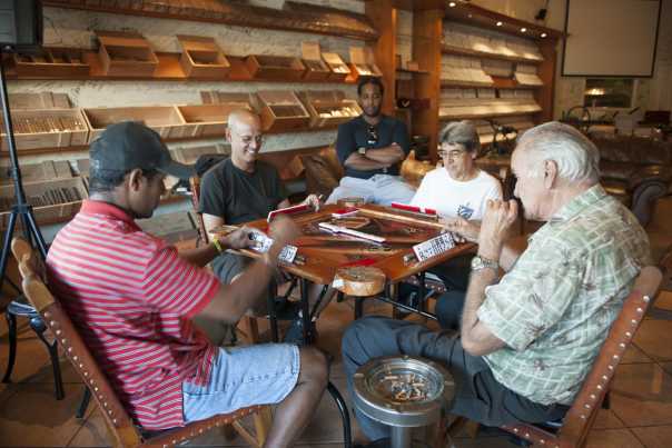 a group of men playing dominoes in a Cuban cigar shop in Little Havana.