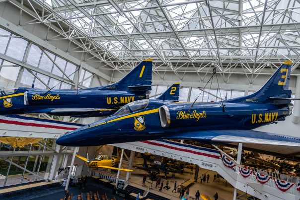 Two Blue Angels planes hanging from the ceiling on display at the National Naval Aviation Museum