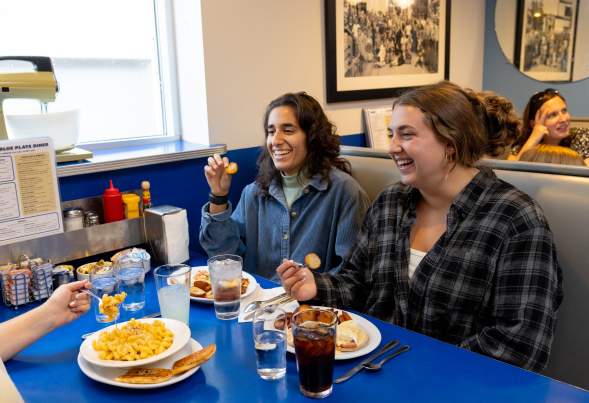 Three young women sitting at a table and enjoying their brunch at Monty's Blue Plate Diner.