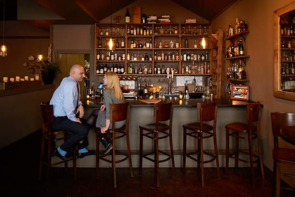 Two people sitting at the bar at Table 128