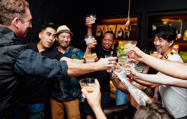 Several people clink glasses at Tales of the Cocktail event in 2023