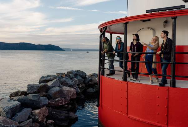 people looking out from a lighthouse platform