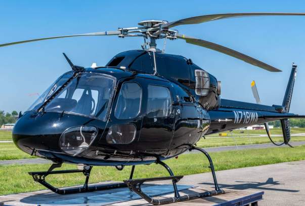 A black helicopter is on the landing pad.