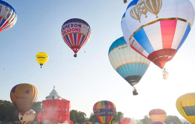 A group of balloons lifting off in a mass ascent at Bristol International Balloon Fiesta - credit Paul Box