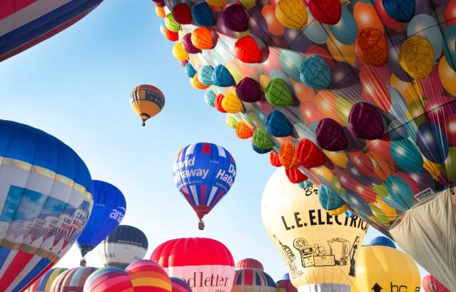 A group of balloons lifting off in a mass ascent at Bristol International Balloon Fiesta - credit Paul Box