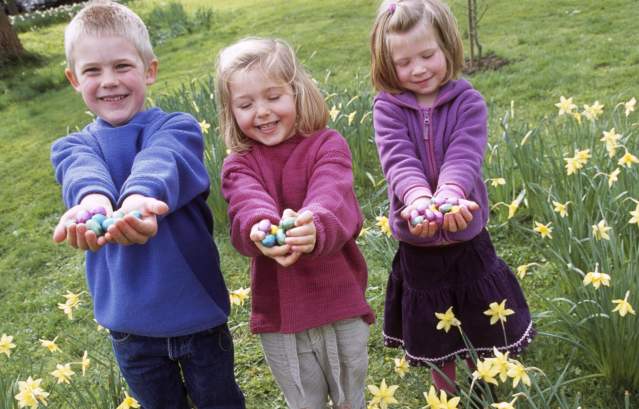 Children holding chocolate Easter eggs in the grounds of Dyrham Park near Bristol