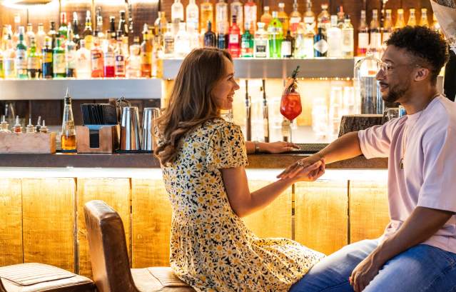 A couple holding hands at the bar on the lower deck of The Square Club in central Bristol - credit Evoke Pictures