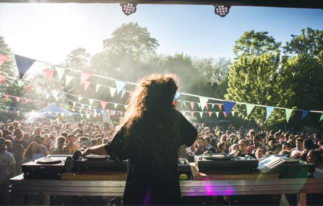 A performer on stage at the Trinity Garden Party Bristol with an audience in the background - credit Khali Ackford