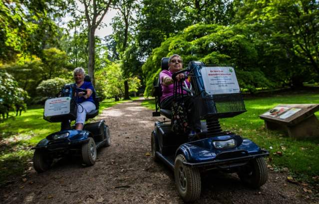 Two mobility scooter users on a path at Westonbirt Arboretum - credit Johnny Hathaway