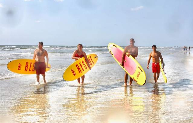 Port Aransas lifeguards hold surfboards in the surf